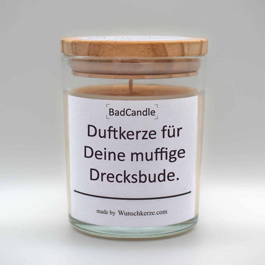 Soja Duftkerze im Glas mit Deckel aus Kiefernholz mit einem Label. Aufschrift: BadCandle - Duftkerze für Deine muffige Drecksbude.