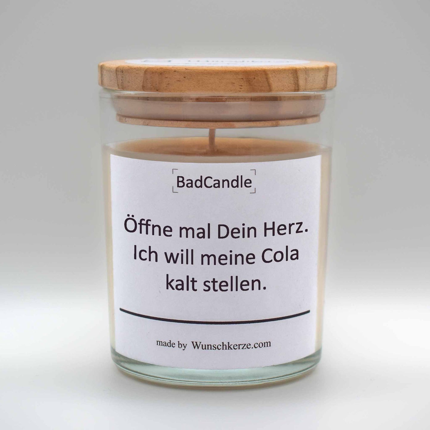 Soja Duftkerze im Glas mit Deckel aus Kiefernholz mit einem Label. Aufschrift: BadCandle - Öffne mal dein Herz. Ich will meine Cola kalt stellen.