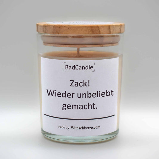 Soja Duftkerze im Glas mit Deckel aus Kiefernholz mit einem Label. Aufschrift: BadCandle - Zack! Wieder unbeliebt gemacht.