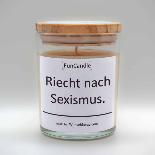 Soja Duftkerze im Glas mit Deckel aus Kiefernholz mit einem Label. Aufschrift:  FunCandle - Riecht nach Sexismus.