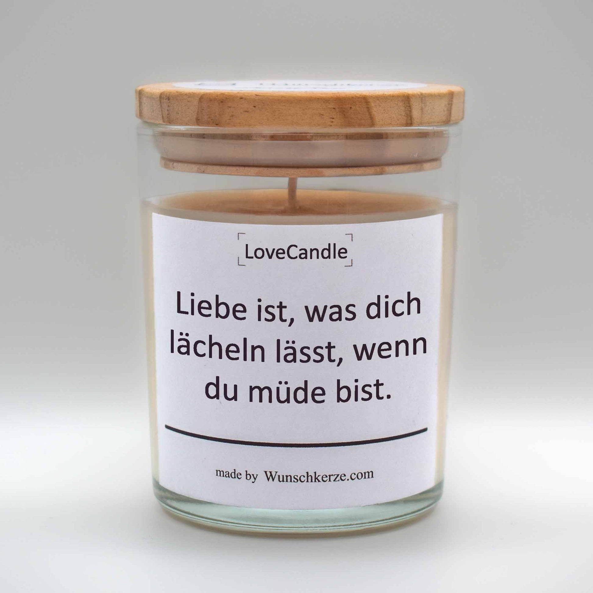 Soja Duftkerze im Glas mit Deckel aus Kiefernholz mit einem Label. Aufschrift: LoveCandle - Liebe ist, was dich lächeln lässt, wenn du müde bist.