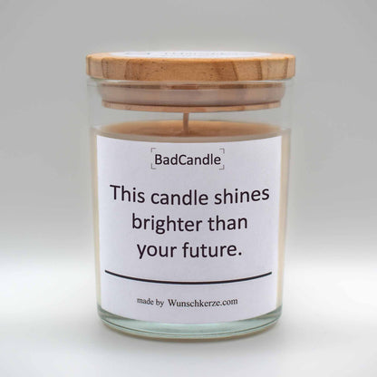 Soja Duftkerze im Glas mit Deckel aus Kiefernholz mit einem Label. Aufschrift: BadCandle - This candle shines brighter than your future.