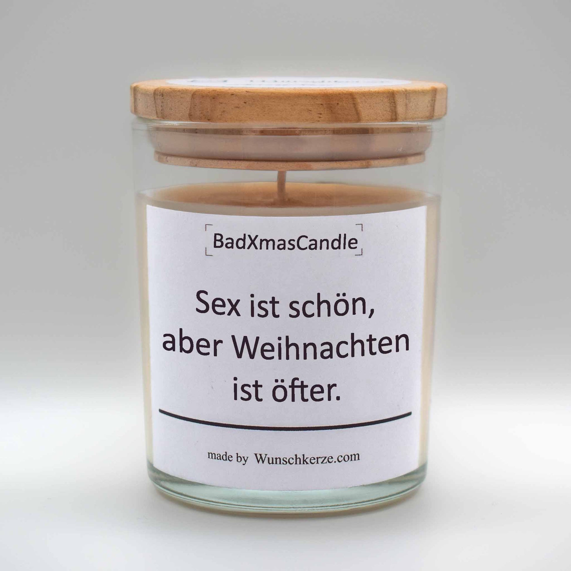 Soja Duftkerze im Glas mit Deckel aus Kiefernholz mit einem Label. Aufschrift:  BadXmasCandle - Sex ist schön, aber Weihnachten öfter.